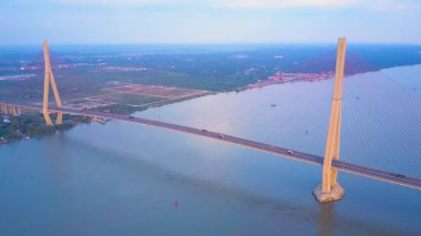 Hava: Çok sayıda otomobil ve motosiklet Vietnamca kasaba ve yeşil doğa doğru önde gelen modern beton köprüyü geçin. Vietnam çamurlu nehir geçiş Karayolu Köprüsü'nün nefes kesen manzarası.
