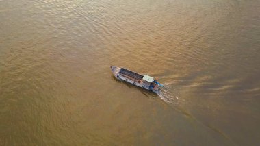 Hava: sakin kirli Nehri Vietnam boyunca seyir boş turist tekne. Küçük bir geleneksel ahşap gemi büyük geçmiş hareket hava serin görünümünden waterfront şehrin tarafından demirlemiş gemisi.
