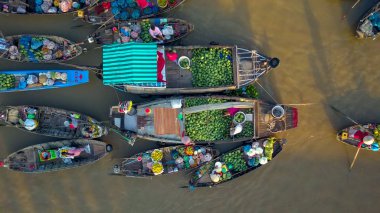 Floating market merchants doing business from their wooden boats floating around the murky river in Vietnam. Locals in the Vietnamese countryside selling their produce from boats. clipart