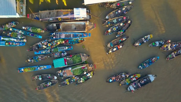 ベトナムで濁った川の周りに浮かんで 木造船からビジネスを行う市場商人をフローティングします 船から彼らの農産物を販売ベトナムの田舎で地元の人々 — ストック写真