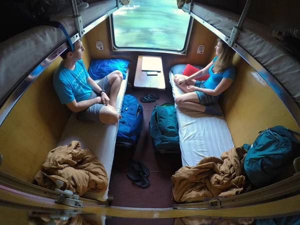 Pencereden uyuyan trende sürme sırasında genç gezgin çift. Rahat sevgiliyi Vietnam serin bir tren ile seyahat eden. Asya boyunca erkek ve kadın backpacking.