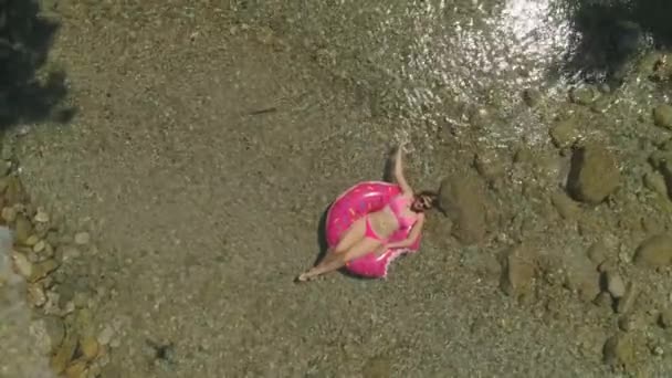 Aerial Laidback Vrouw Een Donut Floatie Zachtjes Strijken Het Water — Stockvideo