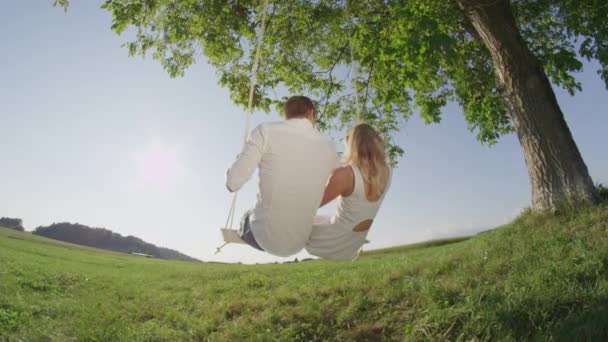 Low Motion Jovem Casal Alegre Balançando Balanço Sob Árvore Verde — Vídeo de Stock