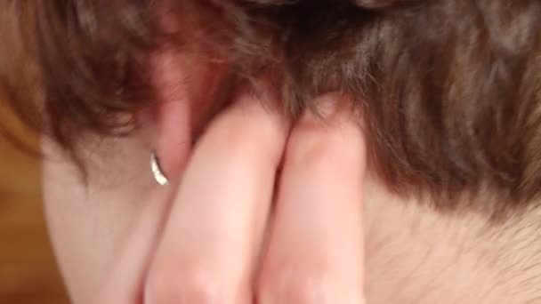 Женщина, страдающая псориазом, царапающая сыпь за ушами — стоковое видео