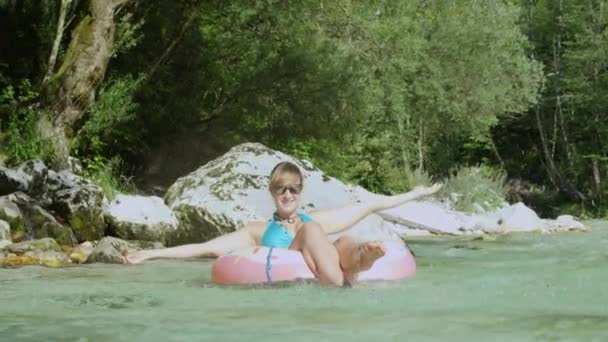 Zeitlupe Nahaufnahme einer fröhlichen Frau, die beim Gleiten den Fluss hinunter Wasser spritzt — Stockvideo