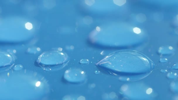 Dof マクロ クローズアップ 車の屋根の防水水色の表面に輝く液体の泡 雨上がりの青い表面に透明な水滴 青い背景に凝縮の泡を反映 — ストック動画