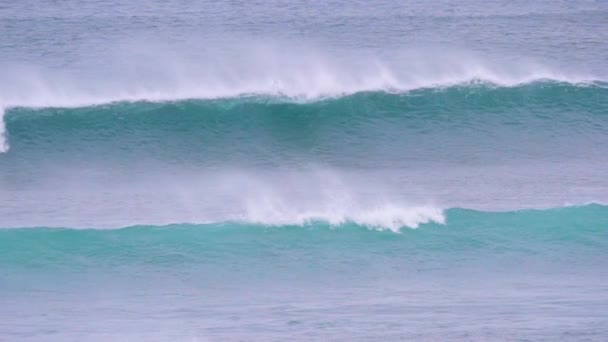 慢动作 大桶波在海岸上逼近 冲浪者在后台排队 专业冲浪者在破浪中划桨 在多云的夏日午后到达阵容 — 图库视频影像