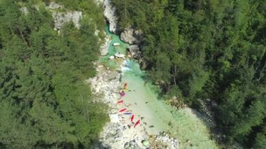 Yaz aylarında dağ vadisinde güzel zümrüt nehri üzerinde Hava Tanınmaz kayakçılar. Bir grup turist Soca akıntısında kayak yapmaya hazırlanıyor. Bütün gün kürek çekerek mola veren insanlar