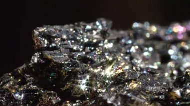 Makro Bokeh: Yoğun metalik yüzeyışık altında parıldayan siyah Hematit. Parlak yüzeyini ortaya çıkaran işlendikten sonra demir oksit mineral formu. Çarpıcı koyu kırılgan mücevher köpüklü