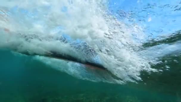 水中スローモーションクローズアップ プロサーファーは ガラスの波に乗って彼のサーフボードに横たわっています 深い青い海で晴れた日にサーフィンの認識できないスポーツマン ロボス島のサーファーズパラダイス — ストック動画