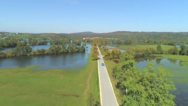 Aerial Blue Car Driving Flooded Fields Sunny Autumn Day People — Stock Video