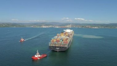 Koper, Slovenya - 7 Haziran 2017 Hava: Küçük tekneler eşliğinde, Maersk kargo gemisi değerli mallarla dolu Msc konteynerleri boşaltmak için yeşil okyanus limanına girmelerine izin verilmesini bekliyor.