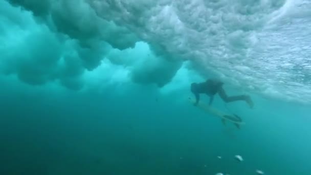スローモーション 野生の波が彼の上にクラッシュするように深い水の中でパドリング勇敢な男性サーファー 海でアヒルのダイビングをしている極端なスポーツマン 威圧的な波の壊れの素晴らしい水中ショット — ストック動画