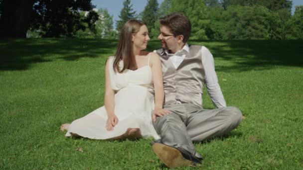 Movimiento Lento Pareja Joven Sienta Hierba Hermoso Parque Iluminado Por — Vídeos de Stock