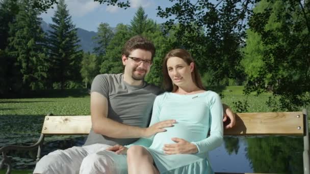 Retrato Adorável Esperando Jovem Casal Alegremente Sentado Banco Madeira Sorrindo — Vídeo de Stock