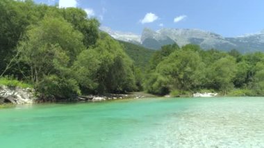 Yavaş Hareket Akan zümrüt yeşili nehir vadinin derinliklerinde ayarlayın. Çarpıcı dağlar ve yeşil ormanlar ile çevrili turkuaz tonları ile kristal berraklığında nehir. Alpler'e gömülü parıldayan Soca nehri