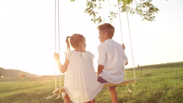 Slow Motion Close Paar Gelukkige Kinderen Knuffelen Slingeren Houten Schommel — Stockvideo