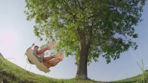 Сміється Дівчина Хлопець Побаченні Погойдуючись Під Великим Старим Деревом Груба — стокове відео