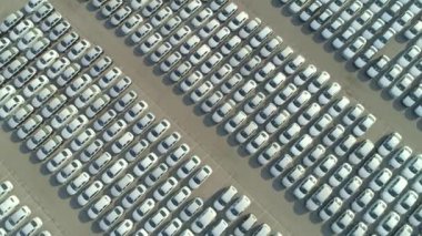 Havadan Yukarıdan Aşağıya: Yepyeni araba büyük otopark ile büyük sanayi bölgesi üzerinde uçan. Birçok beyaz araba büyük liman park alanında satış ve ulaşım bekliyor. Ağır otomobil endüstrisi.