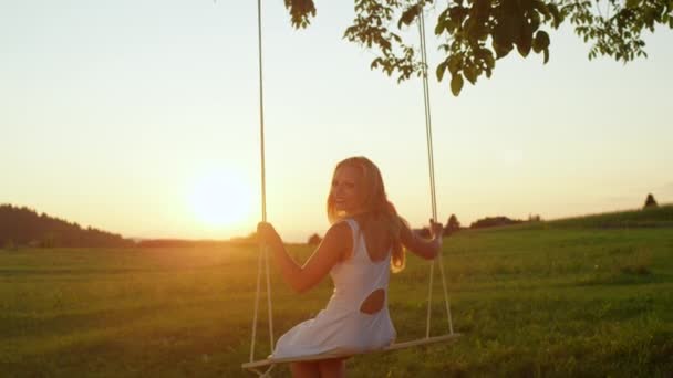 Slow Motion Lens Flare Smiling Young Woman Swaying Rope Swing — Stock Video