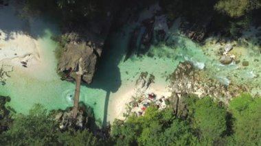 Hava Top Down: Adam zümrüt yeşili nehre küçük ahşap köprüden takla. İnsanlar güzel yaz gününde nehir kenarında dinlendiriyor. Tatile turistler Soca vadisinde nefes kesen doğanın tadını çıkarın.