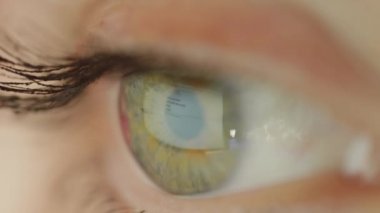 New York, ABD - 4 Haziran 2017: Makro tanınmayan yeşil gözlü kadın Googling ve web tarama. Google web tarayıcısı büyük yeşil gözleri yansıtan. Yeşil göz yüzeyinde Google arama motoru yansıması