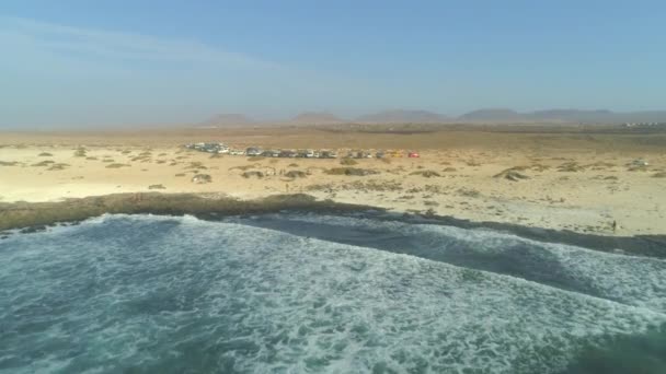 冲浪者和游客在加那利群岛的沙质海岸附近停车 难以辨认的人们从贫瘠的土地上涌向海边 欣赏壮丽的景色和清澈的海水 — 图库视频影像