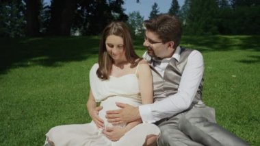 Yavaş Hareket: Genç yakında anne-babalar samimi bir an paylaşan, güneşli bir günde hamile göbek okşama olmak. Heyecanlı çift bebeğin doğmasını bekleyemez. Hamilelik harikaları zevk karı koca.