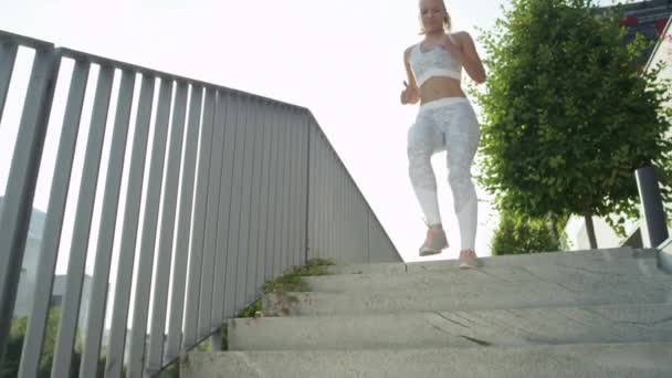 慢动作 低角度 镜头火焰有吸引力的年轻女性在阳光明媚的城市街道上有趣的慢跑 微笑的运动金发女孩在清晨锻炼 健康的生活方式户外活动 — 图库视频影像