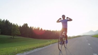Atletik genç erkek yoğun dağ yarışı sırasında onun serin yol bisikleti pedallar üzerinde adım. Güneşli dağlarda Pro yol bisikletçi eğitimi. Yaz doğasında pitoresk bisiklet yolculuğu. Yavaş hareket görüntüleri