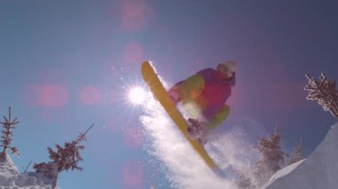 Ağır çekim yakın çekim: güneşli dağ backcountry kar püskürtme toz sürme ve toz döner, yapıyor Extreme snowboard. Eğleniyor snowboard bakırlı taze kar snowboard