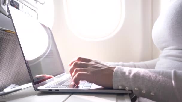 从重要商务会议飞回家时 无法辨认的女性在电脑上键入类型 年轻的白种女性手指在长途飞行中在很酷的高科技笔记本电脑上打字 — 图库视频影像
