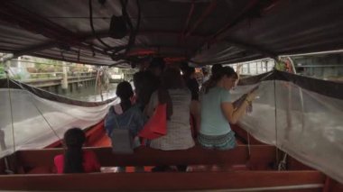 Bangkok, Tayland - Mart 2017: Genç Kafkas turist nehir teknede yerel kadınların yanında oturan ve harita ya bakarak. Bangkok banliyölerinde Chao Phraya nehri aşağı kaba binmek Taylar ve turistler. 