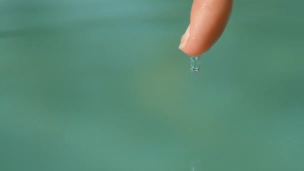 Moción Lenta Macro Dof Pequeña Gota Agua Cae Del Dedo — Vídeos de Stock