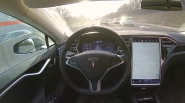 Özerk araba - 1 Şubat 2017: erkek sürücünün direksiyon oturan ve özerk kendi kendine sürüş otomatik pilot Tesla Model S Sürücüsüz araç dinlendirici ve rahat sürüş keyfi