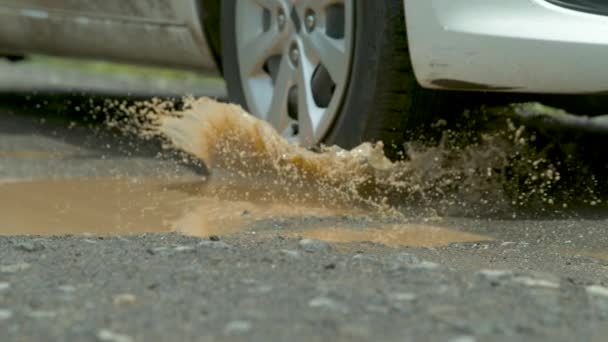 Slow Motion Närbild Skumma Vattenstänk Över Asfaltvägen Som Bil Kör — Stockvideo