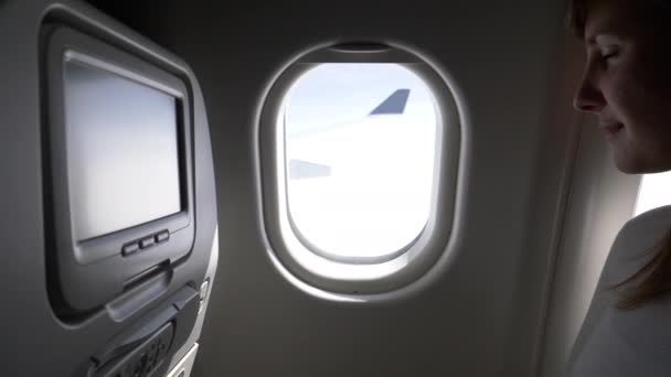 Pov クローズアップ 女性の乗客が日陰を閉じる前に飛行機の窓から見て 女性は長い飛行中に飛行機の窓を通して見て 着陸を開始するためにブラインドを引っ張ります — ストック動画