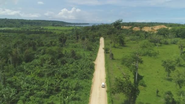 Aerial Furgoneta Blanca Conduce Por Camino Tierra Tropical Hacia Pozo — Vídeos de Stock