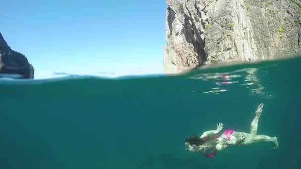 半水中 若い女性はカメラに向かってシュノーケルし パラダイス島の素晴らしい休暇中に のジェスチャーを作る フィットの女性旅行者が完璧な青緑色の水に飛び込むことに興奮 — ストック動画