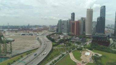 Anteni: hızla büyüyen meşgul karayolu ve uzun boylu kentsel gökdelenler yanında inşaat alanına. Yükselen şehir camsı kuleleri meşgul otoyol trafik ve inşaat sitesi yeşil park yok göz ardı.