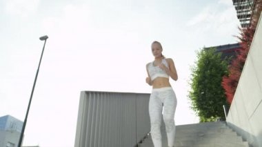 Yavaş Hareket, Düşük Açı, Lens Flare: Atletik sarışın kız koşu ve sabah erken egzersiz. Sıkıştırma giysileri çekici uygun kadın dikkatle beton merdiven bir uçuş aşağı çalışan.