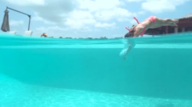 Su, palmiye ağacı ormanda Cennet Adası güneşli Bali tatil yaz zevk sıçramasına ağır çekim yakın kadar güzel gülümseyen kız pembe bikini mayo sonsuzluk havuzu, kenarında oturan