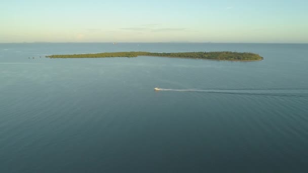 航空写真 小型漁船を散らし青い海に水島を通過するとき 孤独なボートは夏の晴れた日に過去の小さな緑の島移動します 漁師の小さなボートでスピード上空 — ストック動画