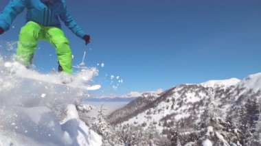 Ağır çekim yakın çekim: güneşli dağ backcountry kar püskürtme toz sürme ve toz döner, yapıyor Extreme snowboard. Eğleniyor snowboard bakırlı taze kar snowboard