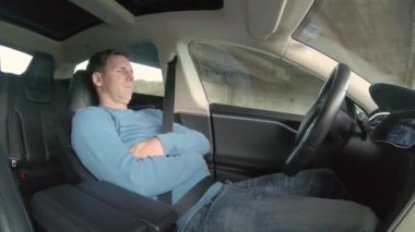 Tesla Autonomous Car, Mart 2018: Akıllı arabası otomatik pilottayken iş adamı işten eve dönerken uyuyor. Kafkas erkek kendi kendine sürüş araba yatan onun gidip sırasında uyur.