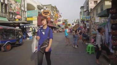 Bangkok, Tayland - Mart 2017, Pov: Turistlerpazarlık alışveriş dolu renkli Khao San yolda yürüyüş. Turistler tezgahları ve restoranlar tarafından yürümek gibi yolun kenarında sarılma Lovely çift. 