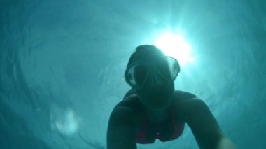 Yavaş Hareket, Sualtı, Selfie, Lens Parlaması: Genç kadın zümrüt okyanusunda dalış yaparken basıncı düzenler. Genç kadın turist Fiji Adaları derin turkuaz sularında mükemmel bir yaz gününde yüzer.