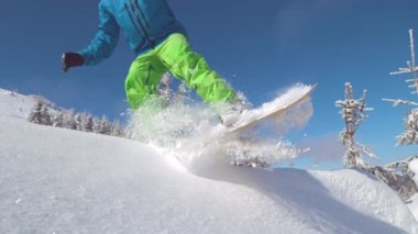 Ağır çekim yakın çekim: güneşli dağ backcountry kar püskürtme toz sürme ve toz döner, yapıyor Extreme snowboard. Eğleniyor snowboard bakırlı taze kar snowboard