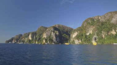 Pov: Pitoresk kireçtaşı uçurumun yakınında demirlemiş çok sayıda yat ve turist teknelerini adada atlamalı turlarda geçiyor. Turist yelkenli ve gemiler güzel Koh Phi Phi Lee adası yakınında doğal koyda dinlenmek