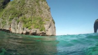 Yavaş Hareket, Yarım Sualtı: Parlak yaz güneşi güzel turkuaz okyanus ve Phi Phi Adaları kireçtaşı kayalıklar heybetli parlar. Pitoresk doğanın yanında sakin deniz pastoral tatil çekimi.